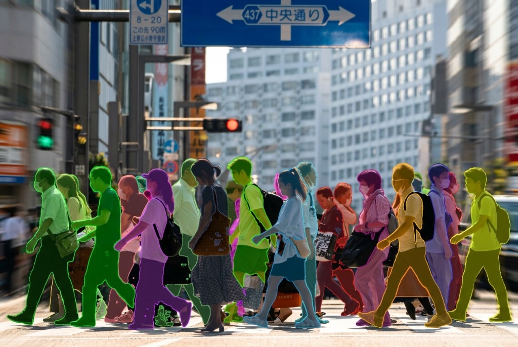 People walking across a busy city street